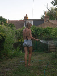 Full length of woman standing against plants