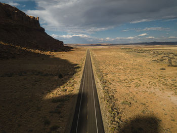 Panoramic view of road leading towards desert against sky