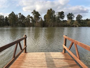 Wooden pier over lake against sky