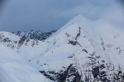 Scenic view of snow covered mountains against sky