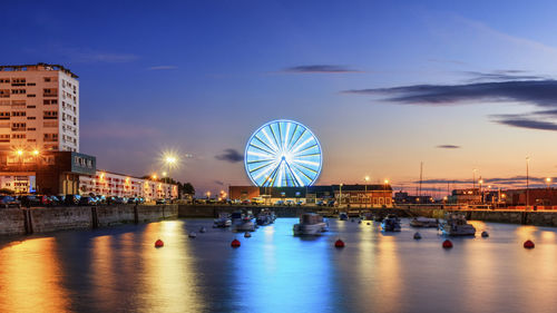 A view of le bassin du paradis, near the harbour of calais. a night view with a big wheel.
