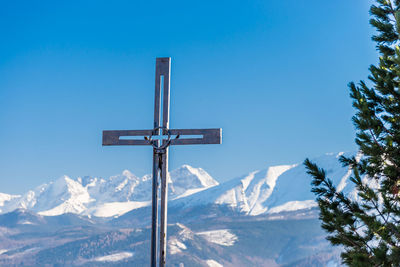 Cross against snowcapped mountains