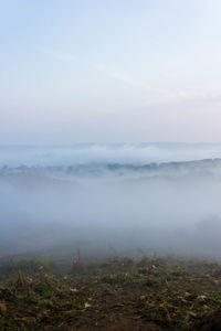 Scenic view of landscape against sky during foggy weather