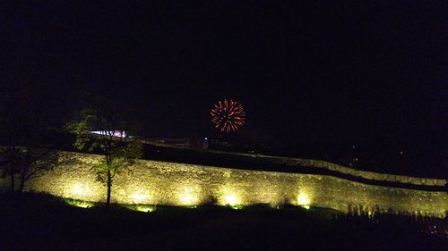 Illuminated built structure against sky at night