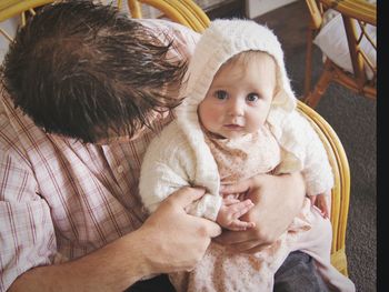 High angle view of father carrying cute daughter on lap