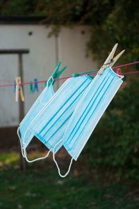 Close-up of medical face masks drying on clothesline