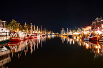 Boats moored at harbor at night