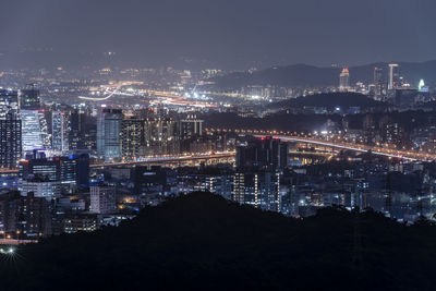 High angle view of illuminated buildings against sky at night