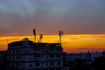 Silhouette of dramatic sky over telecommunications tower during sunset
