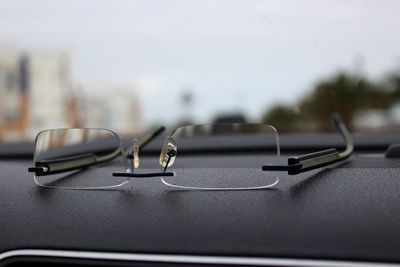 Close-up of eyeglasses on dashboard of car