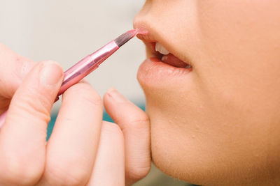 Cropped image of woman applying lipstick