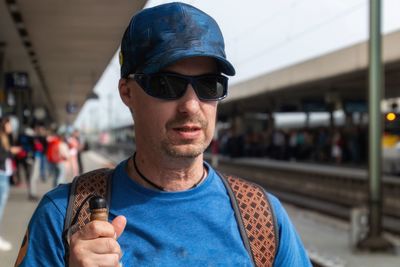 Man wearing sunglasses at railroad station platform