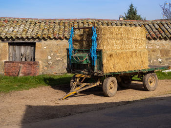 Vintage car on field by road against sky