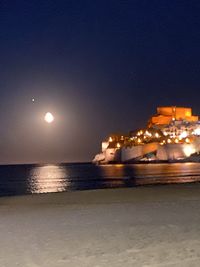 Illuminated sea against sky at night