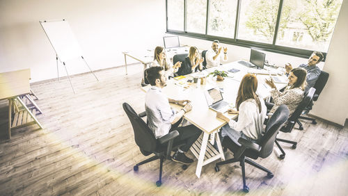 High angle view of people sitting on table