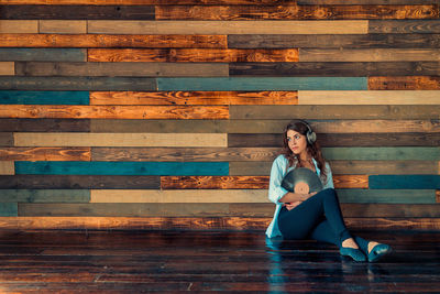 Full length portrait of young woman sitting on steps