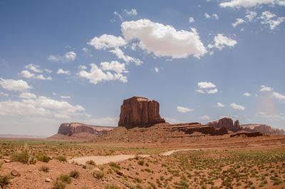 View of rock formations in desert against cloudy sky