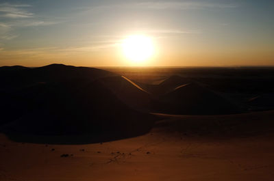 Scenic view of desert against sky during sunset