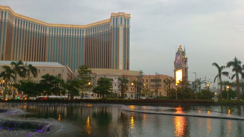 Illuminated buildings by city against sky