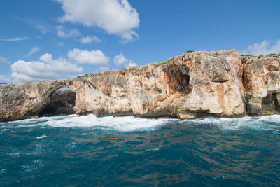 Rock formations by sea against sky