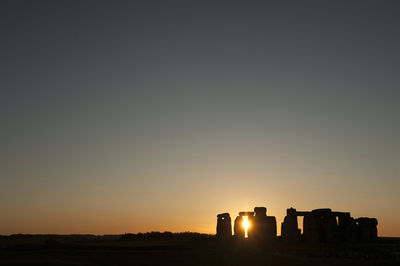 Silhouette landscape against clear sky during sunset