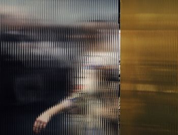 Woman seen through patterned glass window