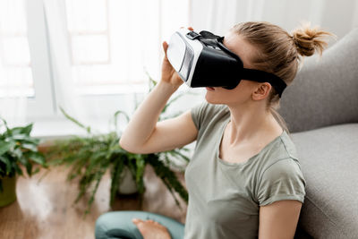 Vr yoga. a young woman sits in a lotus position in a virtual reality headset, doing yoga 