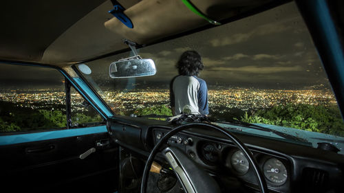 Rear view of man driving car against sky