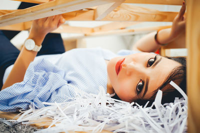 Close-up portrait of young woman lying on floor