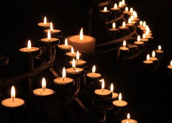 Close-up of lit tea light candles at night
