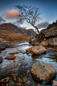 Looking down through glen coe to the mountains known as the three sisters after a winter sunset