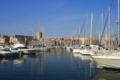 Sailboats moored in harbor