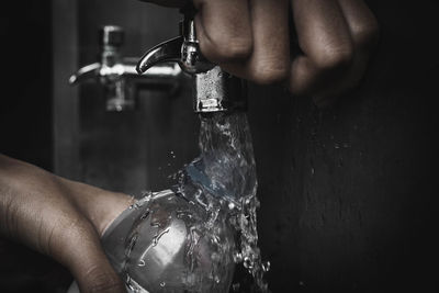 Midsection of person holding glass with water