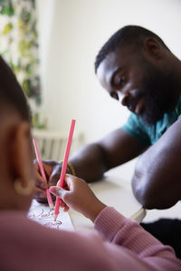 Father and daughter drawing together at home