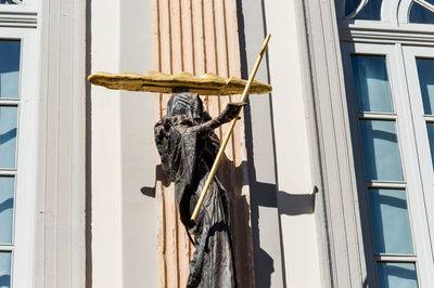 Statue hanging on wooden window of building