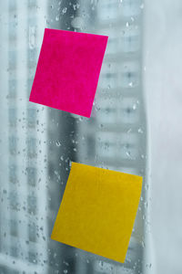 Close-up of yellow glass with text on paper