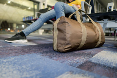 Low section of woman sitting at airport