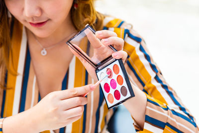 Midsection of woman holding mobile phone