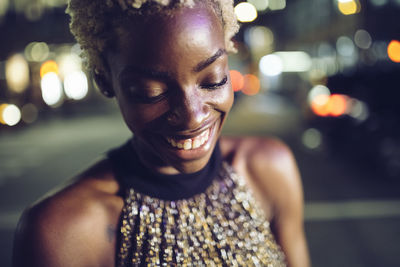 Portrait of happy young woman at night