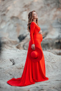 Young woman looking away while standing outdoors