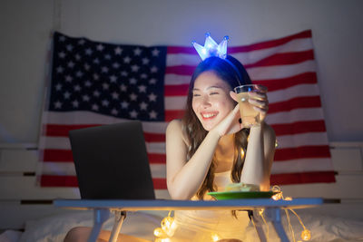 Young woman using mobile phone at table