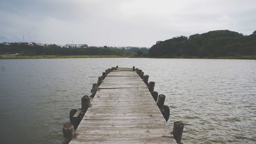 Pier over lake against sky