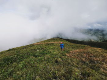 Rear view of person on landscape against sky