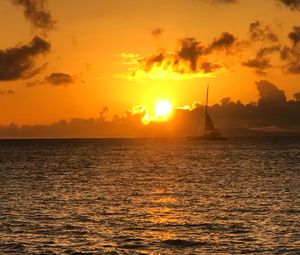 Silhouette sailboat sailing on sea against sky during sunset