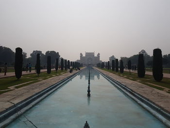 Reflection of buildings in water against clear sky