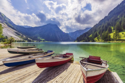 Panoramic view of boats moored in lake against sky