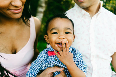 Cropped portrait of a baby laughing and covering his mouth