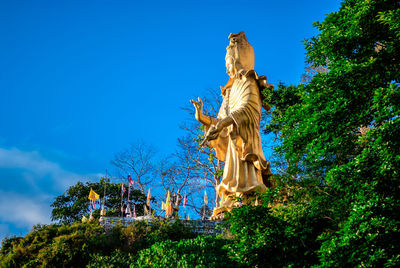 Low angle view of statue against blue sky