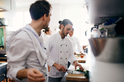 Male chef chopping vegetable in commercial kitchen