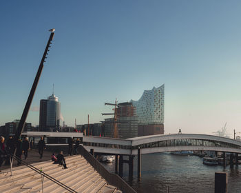 Bridge over river against buildings in city